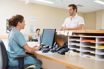 Image showing Nurse And Patient Conversing At Reception Desk