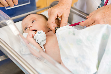 Image showing Female Doctor's Hands Examining Newborn Babygirl In Hospital