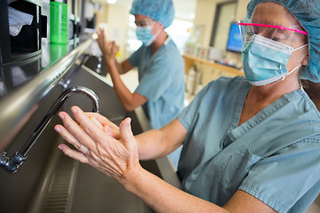 Image showing Female Surgeon Scrubbing Hands and Arms