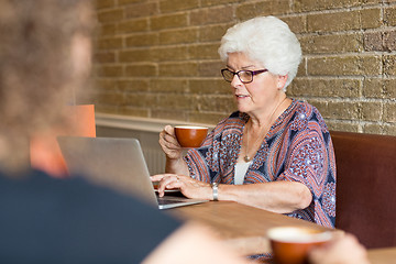 Image showing Customer Using Laptop While Having Coffee In Cafe