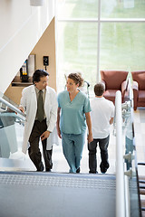 Image showing Doctor And Nurse Discussing While Walking On Stairs