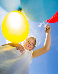 Image showing Happy Girl Holding Balloons Against Sky