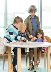 Image showing Children Using Tablet Computer At Desk In Library