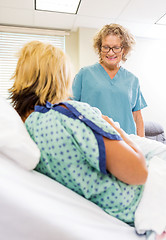 Image showing Happy Nurse Looking At Newborn Babygirl With Mother In Hospital