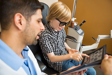 Image showing Boy Reading Test Chart While Optometrist