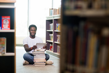 Image showing Student With Digital Tablet And Books Sitting In Library