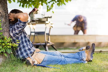 Image showing Manual Worker Leaning On Tree Trunk