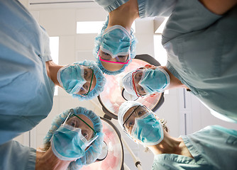 Image showing Medical Team Wearing Masks And Scrubs In Operation Room