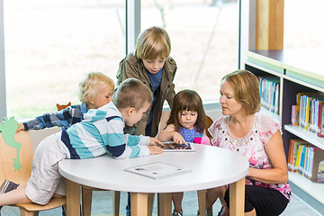 Image showing Teacher With Students Using Digital Tablets In Library