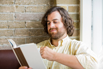 Image showing Man Reading Book In Coffeeshop