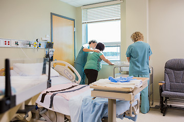 Image showing Nurse Comforting Pregnant Woman At Window In Hospital Room