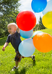 Image showing Happy Boy With Balloons Walking In Park