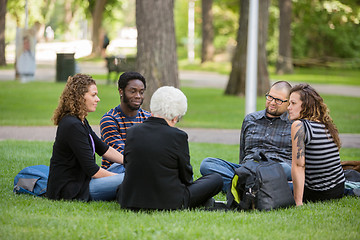 Image showing Multiethnic Friends Relaxing On Grass At Campus