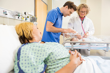 Image showing Doctor Examining Newborn Baby While Parents Looking At Her