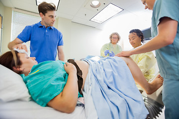 Image showing Man Looking At Medical Team Operating Pregnant Woman