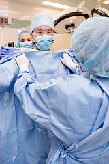 Image showing Surgeon Putting on Sterile Surgical Gown