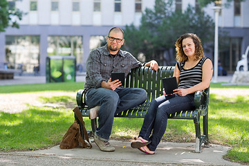 Image showing Confident Students Sitting On Bench At University Campus