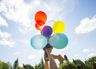 Image showing Mother And Daughter Holding Balloons Against Sky