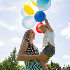 Image showing Mother And Daughter Playing With Balloons Against Sky