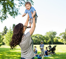 Image showing Playful Mother Lifting Baby Boy In Park