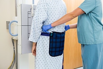 Image showing Nurse Adjusting Apron On Patient Before Xray