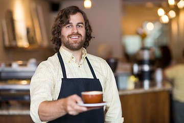 Image showing Confident Waiter Holding Coffee Cup In Cafe