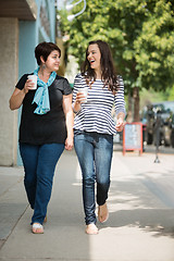 Image showing Friends With Disposable Coffee Cups Walking On Pavement