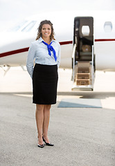 Image showing Beautiful Stewardess Standing Against Private Jet