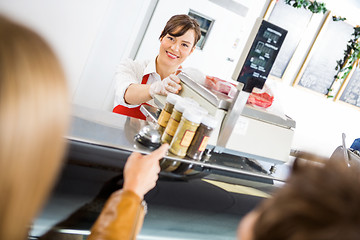 Image showing Saleswoman At Counter Attending Customers In Butcher's Shop