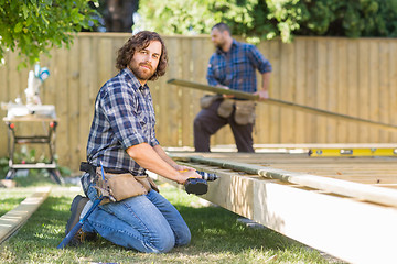 Image showing Worker Drilling Wood At Construction Site