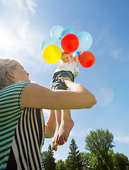 Image showing Happy Mother And Daughter Playing With Balloons Against Sky