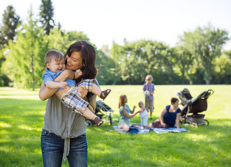 Image showing Young Woman Carrying Baby Boy In Park