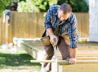 Image showing Worker Sawing Wood At Construction Site