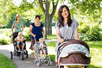 Image showing Beautiful Mother Pushing Baby Stroller In Park