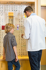 Image showing Optometrist And Boy Choosing Eyewear In Store