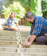 Image showing Carpenters Measuring Wood With Tape At Site