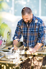 Image showing Happy Carpenter Marking On Wood At Table Saw