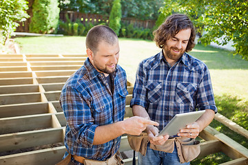 Image showing Worker Pointing At Digital Tablet While Discussing Project With