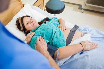 Image showing Pregnant Woman Smiling While Being Consoled By Husband In Hospit