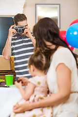 Image showing Man Taking Picture Of Family At Birthday Party