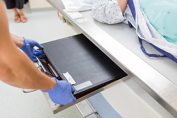 Image showing Nurse Adjusting Film In Xray Table