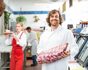 Image showing Portrait Of Happy Butcher Holding Meat Package