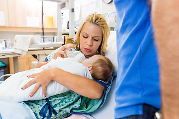 Image showing Woman Feeding Milk To Newborn Baby On Hospital Bed