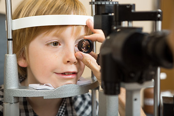 Image showing Optician's Hand Checking Boy's Eye With Lens