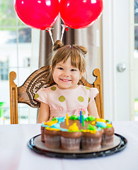 Image showing Happy Girl Sitting In Front Of Cake At Home