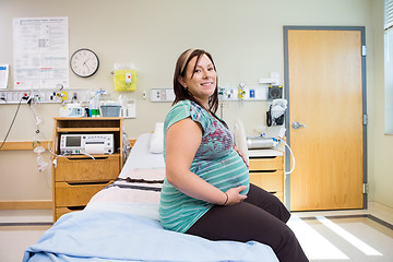 Image showing Happy Pregnant Woman With Hands On Stomach On Hospital Bed