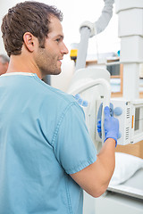 Image showing Male Nurse Adjusting Xray Machine