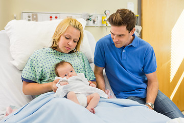 Image showing Couple Looking At Newborn Baby In Hospital Room