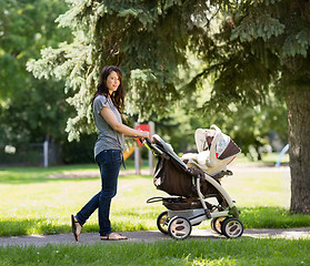 Image showing Young Mother Pushing Stroller In Park