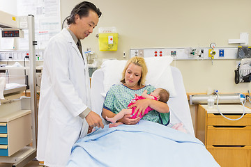 Image showing Mother Looking At Doctor Playing With Newborn Babygirl